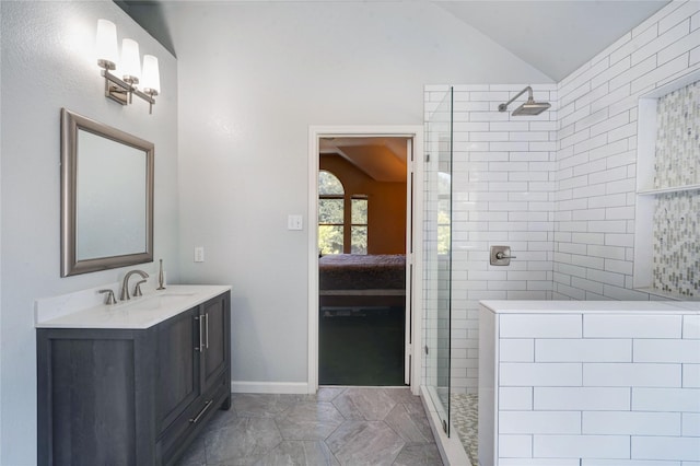 bathroom with vaulted ceiling, a tile shower, and vanity