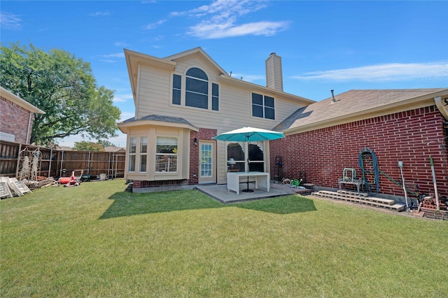 back of property with a lawn and a patio