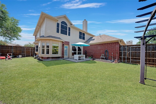 rear view of property featuring a yard and a patio area