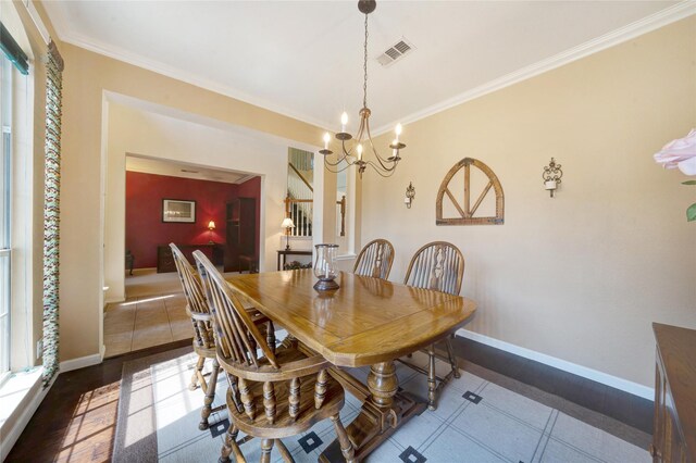 dining space with a chandelier, crown molding, and hardwood / wood-style floors