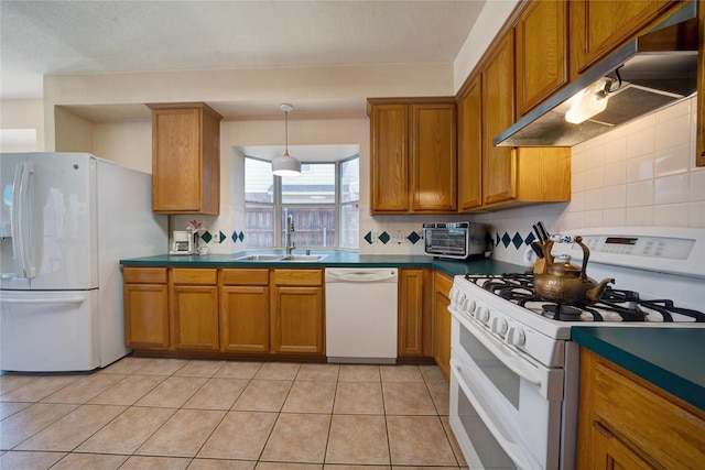 kitchen featuring sink, backsplash, white appliances, and hanging light fixtures