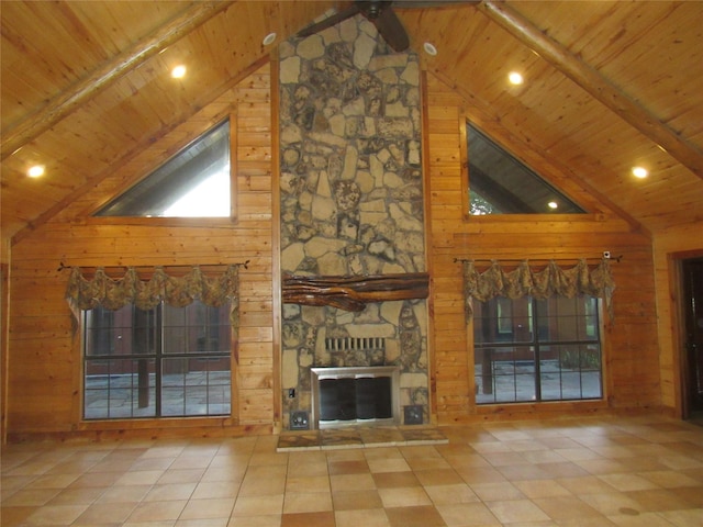 unfurnished living room featuring wood ceiling, a fireplace, and wooden walls