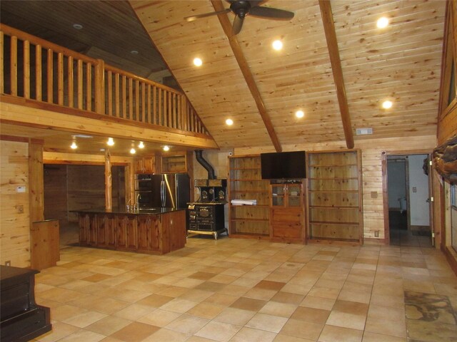 interior space with wood walls, high vaulted ceiling, wood ceiling, and ceiling fan