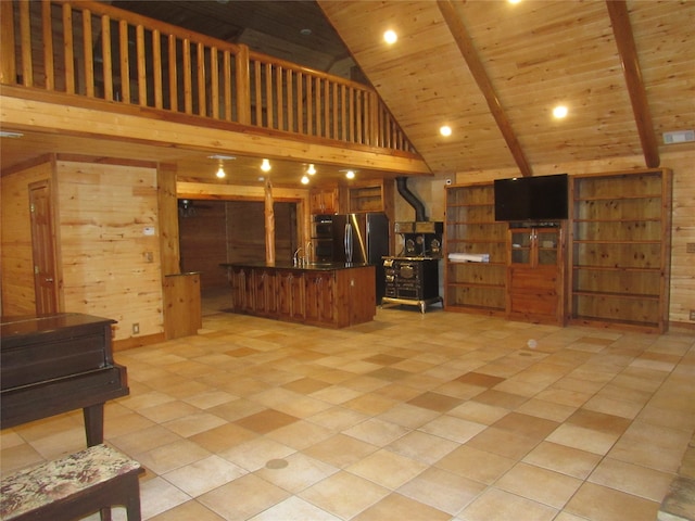 kitchen featuring stainless steel fridge, wooden ceiling, light tile patterned floors, high vaulted ceiling, and wooden walls