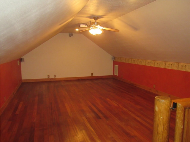 additional living space featuring lofted ceiling, ceiling fan, dark hardwood / wood-style flooring, and a textured ceiling