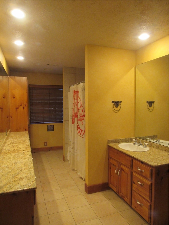 full bathroom with baseboards, vanity, and tile patterned floors