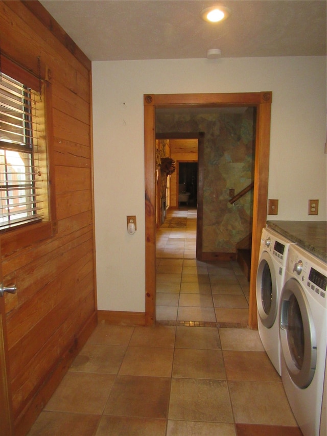 laundry room with wooden walls and washer and clothes dryer