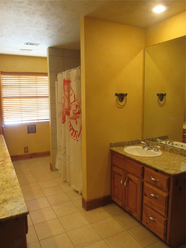 bathroom with vanity, a textured ceiling, curtained shower, and tile patterned flooring