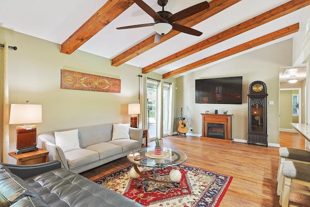 living room with ceiling fan, vaulted ceiling with beams, and light hardwood / wood-style floors