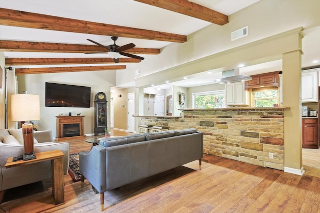 living room featuring ceiling fan, light hardwood / wood-style flooring, and lofted ceiling with beams