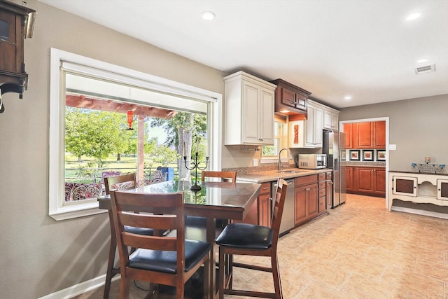 kitchen with light stone countertops, sink, and stainless steel appliances