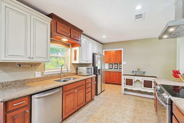 kitchen with appliances with stainless steel finishes, extractor fan, light stone counters, and sink