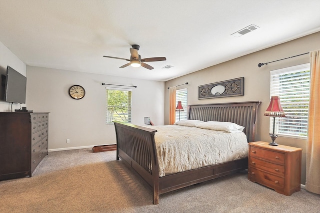 bedroom with ceiling fan, carpet floors, and multiple windows