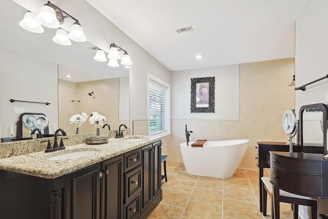 bathroom featuring a bathing tub, tile walls, tile patterned floors, and vanity