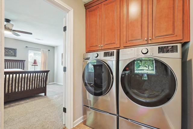 laundry area with washing machine and dryer, ceiling fan, light colored carpet, and cabinets