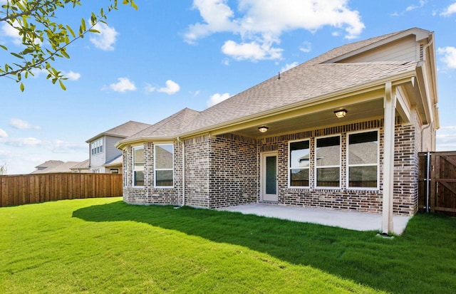 rear view of house with a lawn and a patio area