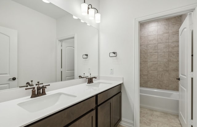 bathroom with tile patterned flooring, vanity, and tiled shower / bath