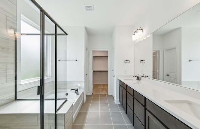 bathroom featuring shower with separate bathtub, vanity, and tile patterned floors