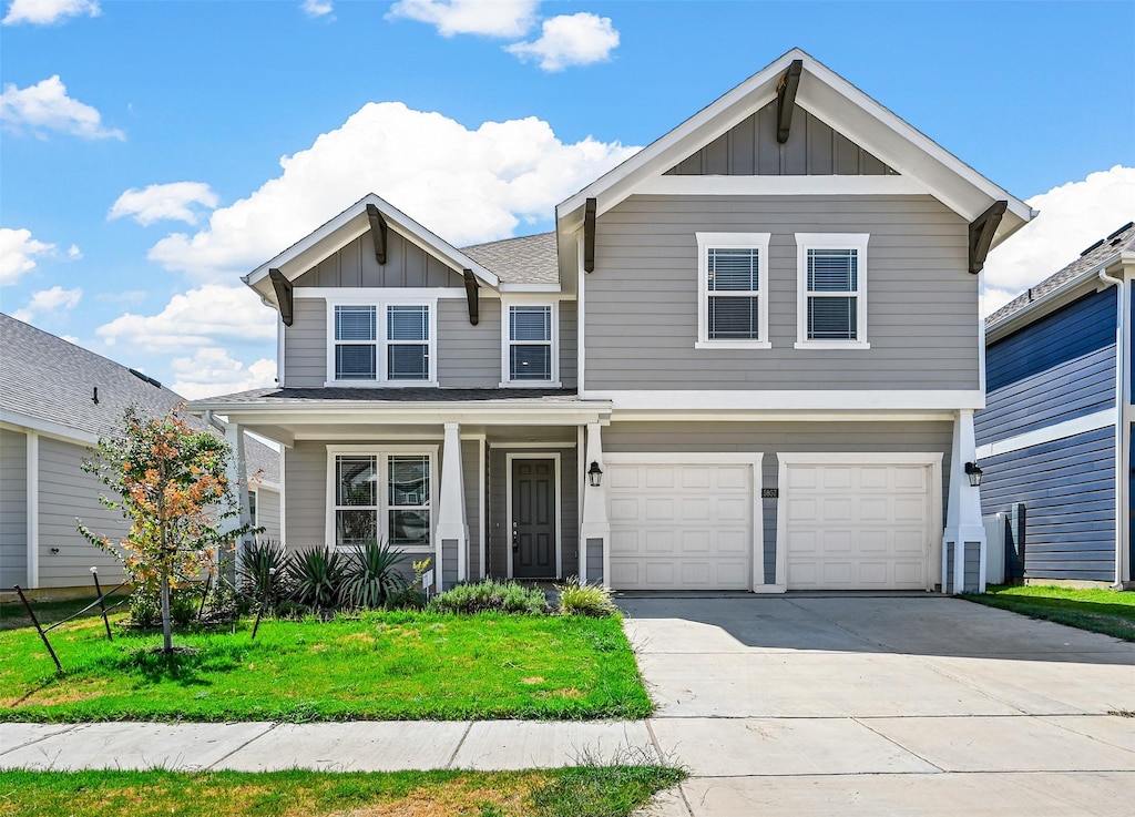 view of front of house featuring driveway, a front lawn, board and batten siding, and an attached garage