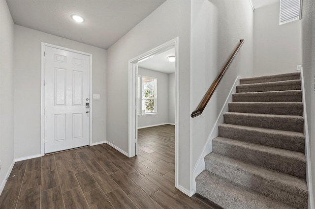 foyer featuring dark wood-style floors, stairway, visible vents, and baseboards