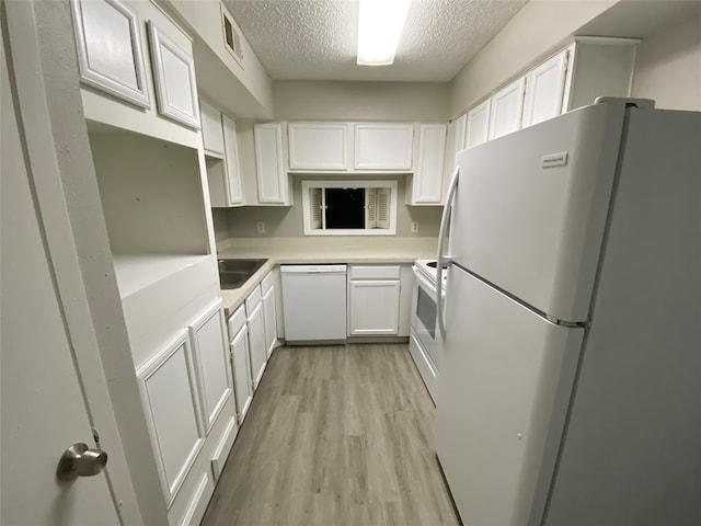 kitchen with white cabinetry, light hardwood / wood-style floors, sink, a textured ceiling, and white appliances