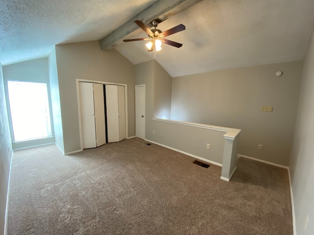 additional living space featuring carpet flooring, ceiling fan, and lofted ceiling with beams