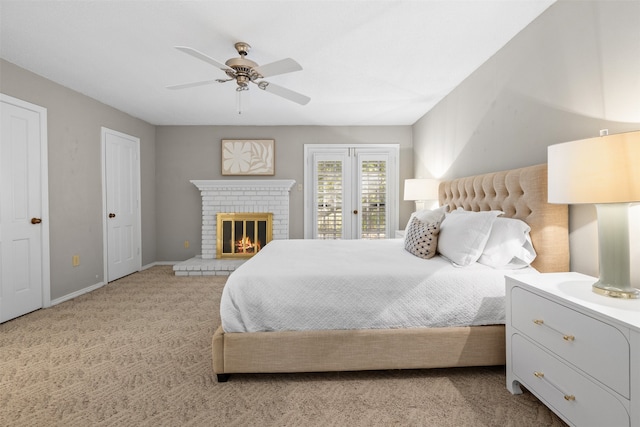 carpeted bedroom featuring ceiling fan, a fireplace, and access to exterior