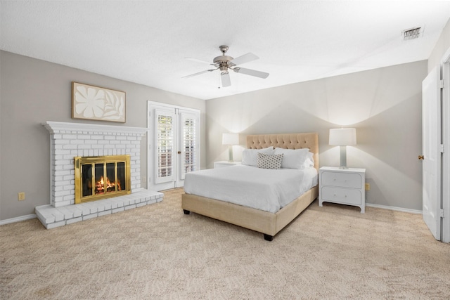 carpeted bedroom with ceiling fan, access to outside, and a fireplace