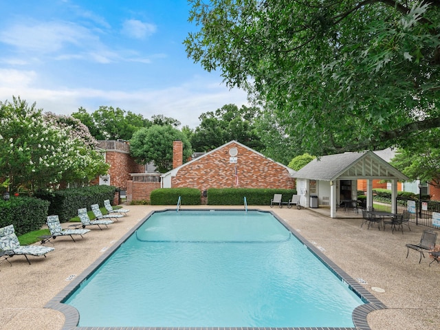 view of swimming pool featuring an outbuilding and a patio area