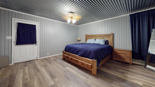 bedroom featuring hardwood / wood-style floors, crown molding, and ceiling fan