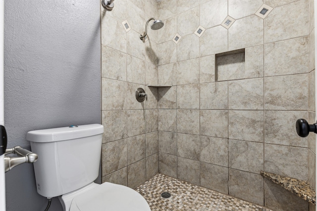 bathroom with toilet and tiled shower