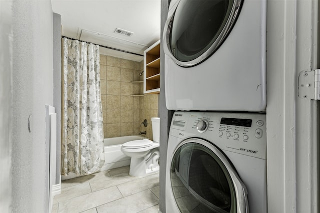 laundry room featuring stacked washer and clothes dryer and light tile patterned floors