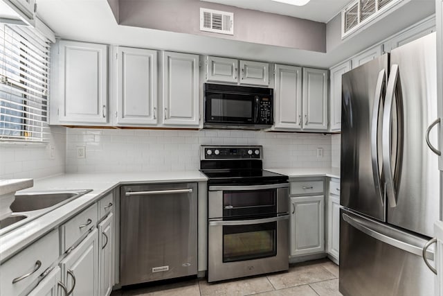 kitchen featuring tasteful backsplash, visible vents, appliances with stainless steel finishes, light countertops, and gray cabinetry