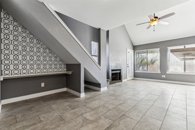 unfurnished living room with high vaulted ceiling, ceiling fan, light tile patterned flooring, and a tiled fireplace