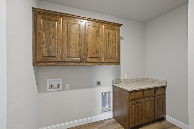 washroom with hookup for a washing machine, wood-type flooring, hookup for an electric dryer, and cabinets