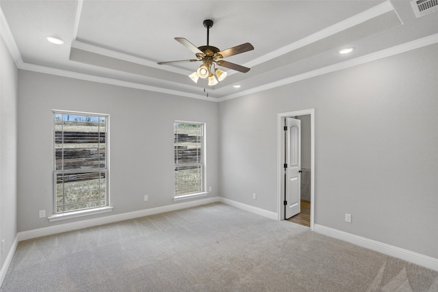 unfurnished room featuring light carpet, ornamental molding, a tray ceiling, and ceiling fan