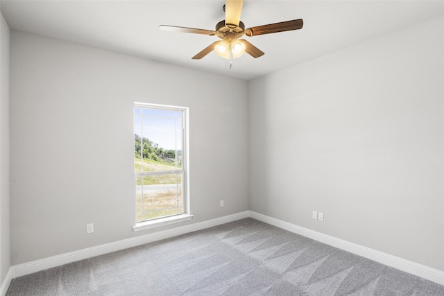 empty room with ceiling fan and light carpet