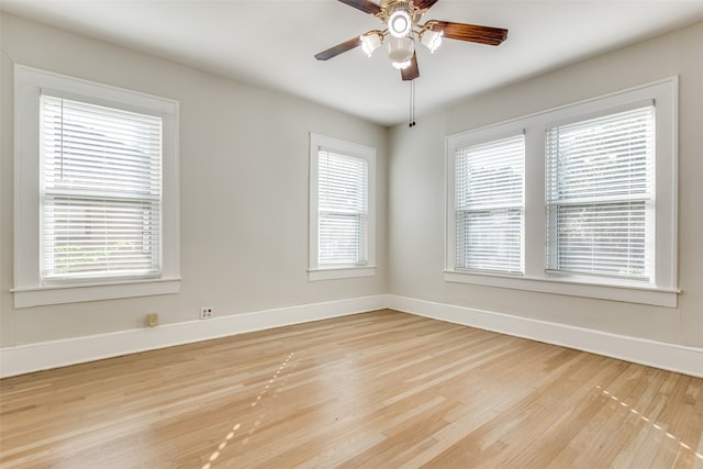 empty room with ceiling fan, plenty of natural light, and light hardwood / wood-style floors