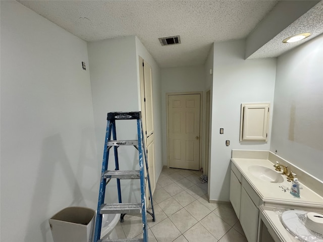 bathroom featuring a textured ceiling, tile patterned flooring, vanity, visible vents, and baseboards