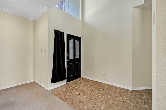 carpeted entrance foyer with crown molding and a textured ceiling