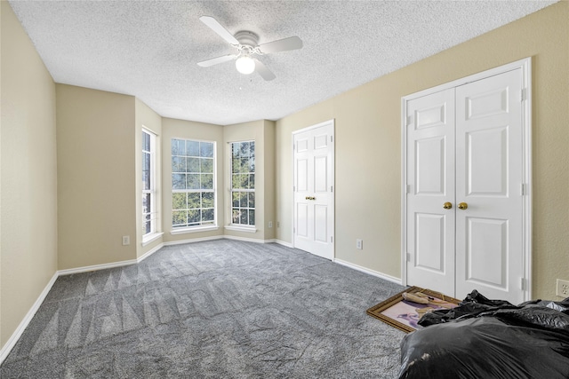 unfurnished bedroom with a ceiling fan, a textured ceiling, baseboards, and carpet flooring