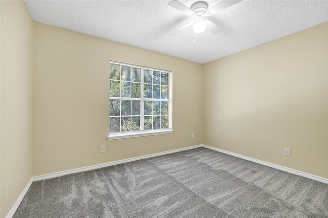 carpeted empty room featuring ceiling fan, a textured ceiling, and baseboards