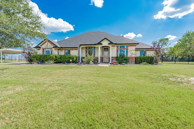 view of front of property featuring stone siding, fence, a carport, and a front yard