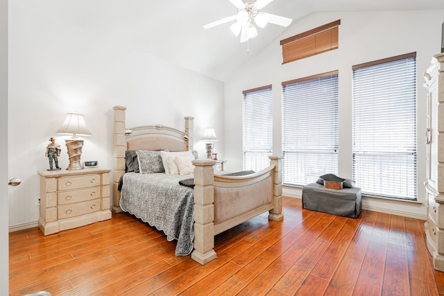 bedroom with high vaulted ceiling, ceiling fan, multiple windows, and light wood-type flooring