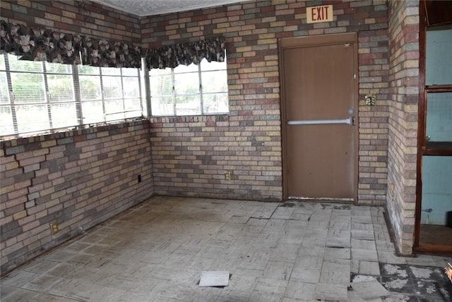 empty room featuring brick wall