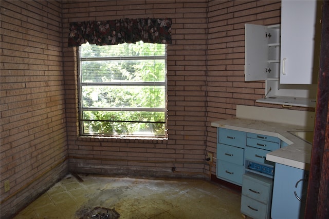 kitchen featuring tile patterned flooring and brick wall