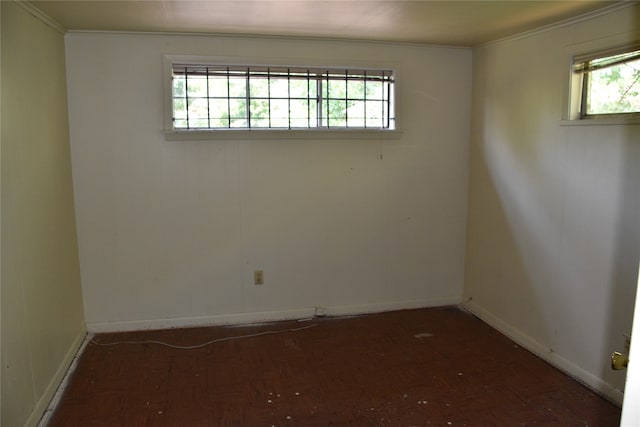 spare room with plenty of natural light, crown molding, and parquet floors