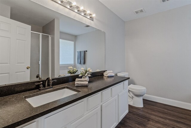 bathroom with vanity, hardwood / wood-style flooring, toilet, and walk in shower