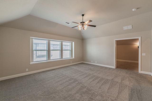 carpeted spare room featuring vaulted ceiling and ceiling fan