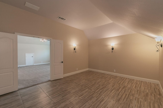 unfurnished room with vaulted ceiling